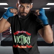 Claim Your Victory Tee modeled by a determined boxer in a black t-shirt featuring the motivational 'Rise, Fight, Win' design, set against a boxing ring background.