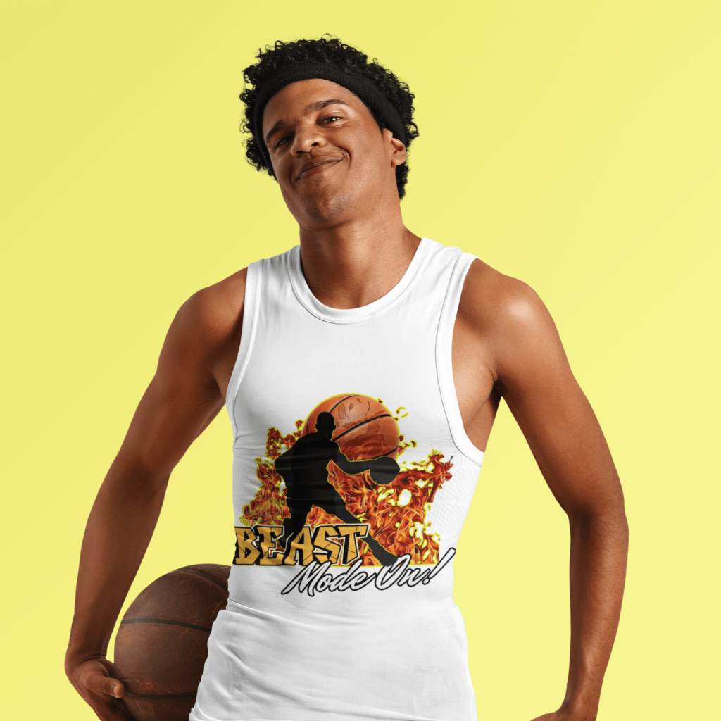 A confident male basketball player wearing the Beast Mode On Sleeveless Tee in white, featuring a fiery basketball-themed design with a bold silhouette and intense flames. He is holding a basketball and smiling, embodying the energy and passion of the game. The sleeveless tee provides a sporty and athletic look, perfect for basketball lovers and gym enthusiasts.