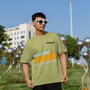 Stylish olive green oversized T-shirt with a motivational quote 'CREATE YOUR SUNSHINE EVEN ON THE CLOUDIEST DAYS.' Contrasting sky-blue, orange/yellow, and white text with a sun icon. DTG-printed on premium 240 GSM cotton fabric. Large size.