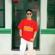 Motivational red oversized tee with an uplifting 'CREATE YOUR SUNSHINE EVEN ON THE CLOUDIEST DAYS' design. Includes bright sky-blue, orange/yellow, and white text with a sun icon. DTG-printed on soft 240 GSM cotton. Medium size.