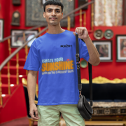 Royal blue oversized T-shirt with a motivational 'CREATE YOUR SUNSHINE EVEN ON THE CLOUDIEST DAYS' design in sky-blue, orange/yellow, and white text with a sun icon. DTG-printed on premium 240 GSM cotton fabric. Extra Small size.