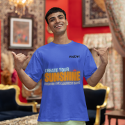 Bold royal blue oversized T-shirt featuring an uplifting 'CREATE YOUR SUNSHINE EVEN ON THE CLOUDIEST DAYS' design. Sky-blue, orange/yellow, and white text with a sun icon. DTG-printed on high-quality 240 GSM cotton fabric. Small size.