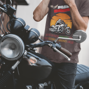 Coffee brown Road Warrior tee in small size, designed for motorcycle enthusiasts who embrace freedom and the thrill of the ride. The striking biker silhouette, bold typography, and adventurous sunset backdrop create a powerful biker statement.