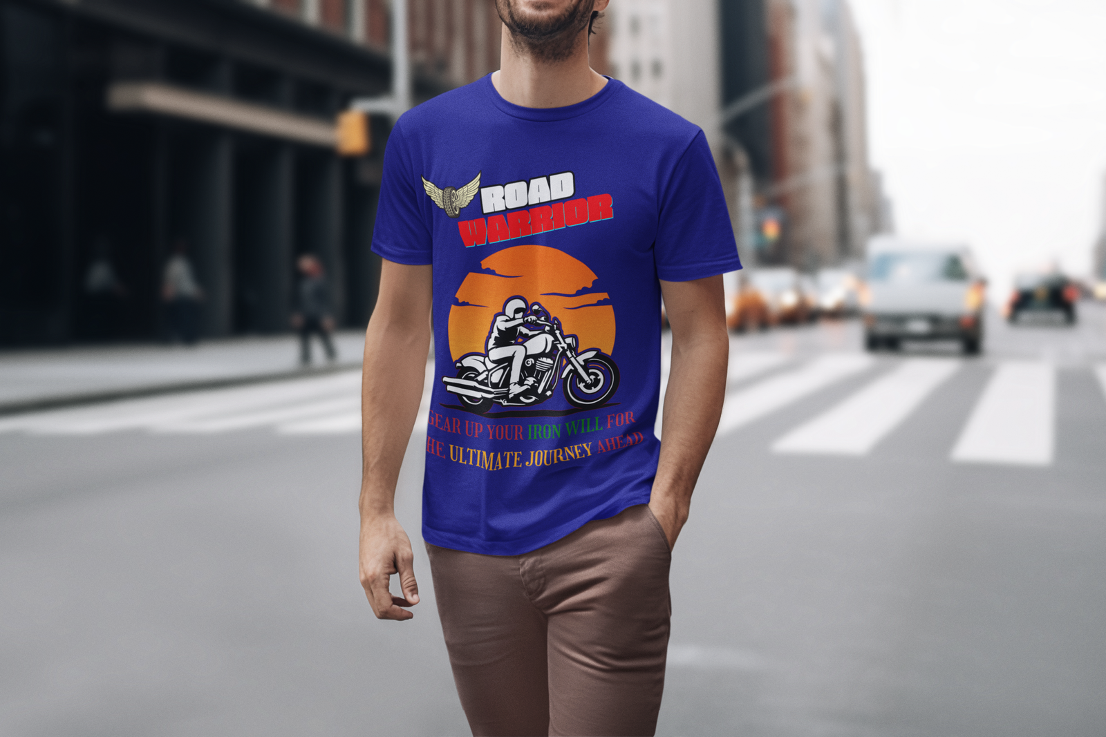 A man walking confidently in the city, wearing the royal blue Road Warrior tee. The bold motorcyclist silhouette, fiery sunset backdrop, and motivational text create a striking visual statement, capturing the fearless and adventurous spirit of bikers.