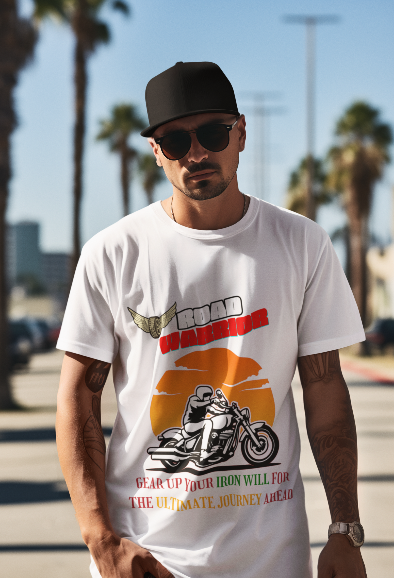 A stylish biker wearing the Road Warrior Tee in white, standing confidently in an urban setting with palm trees in the background. The t-shirt features a bold motorcyclist graphic riding against an eye-catching orange sunset, symbolizing adventure and freedom. The "ROAD WARRIOR" text is prominently displayed in bold white and red letters with a winged tire emblem, adding a classic biker aesthetic. Below, the phrase "GEAR UP YOUR IRON WILL FOR THE ULTIMATE JOURNEY AHEAD" is styled in red, green, and yellow, reinforcing the fearless biker theme. A must-have for motorcycle enthusiasts, road warriors, and thrill-seekers.
