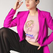 Woman in a soft baby pink 'Bloom Yourself' T-shirt, decorated with an elegant floral and butterfly print. A feminine and graceful style statement, available at PodLyft.