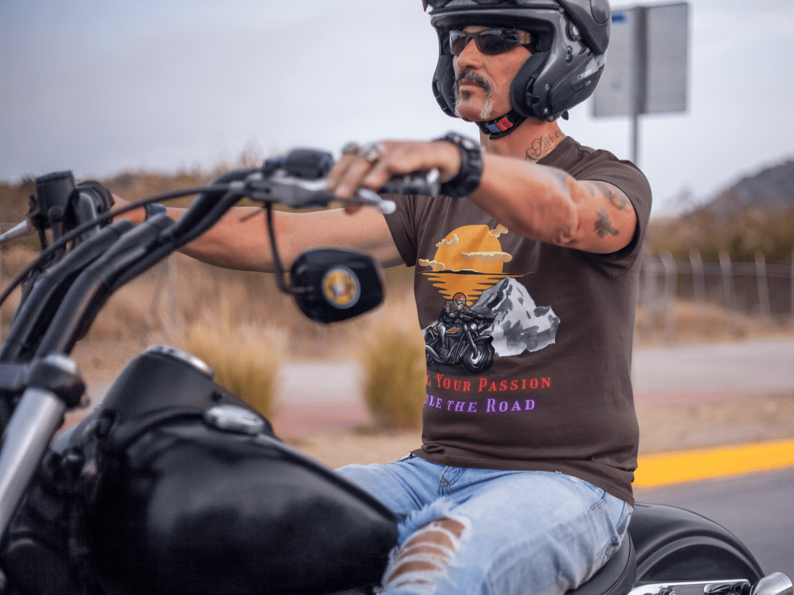 A man in a t-shirt rides a motorcycle, featuring a striking biker graphic that captures the essence of adventure.