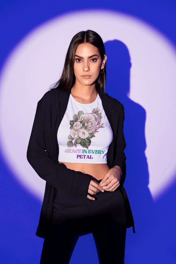 Grace in Every Petal Tee – A stylish floral crop top featuring a beautifully detailed bouquet design, worn by a confident model against a striking blue-lit backdrop. A perfect blend of elegance and modern fashion.