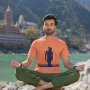 Spiritual Krishna Tee in coral, showcasing a stunning silhouette of Lord Krishna playing the flute with a glowing sunset background and 'जय श्रीकृष्ण' text. Ideal for yoga, meditation, and devotion.