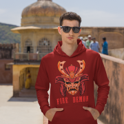 Men’s Fire Demon Samurai Hoodie by PodLyft in maroon, on a mannequin, featuring a bold red and orange samurai helmet design with a demonic face and 'FIRE DEMON' text, displayed in a modern store with blurred clothing racks in the background.