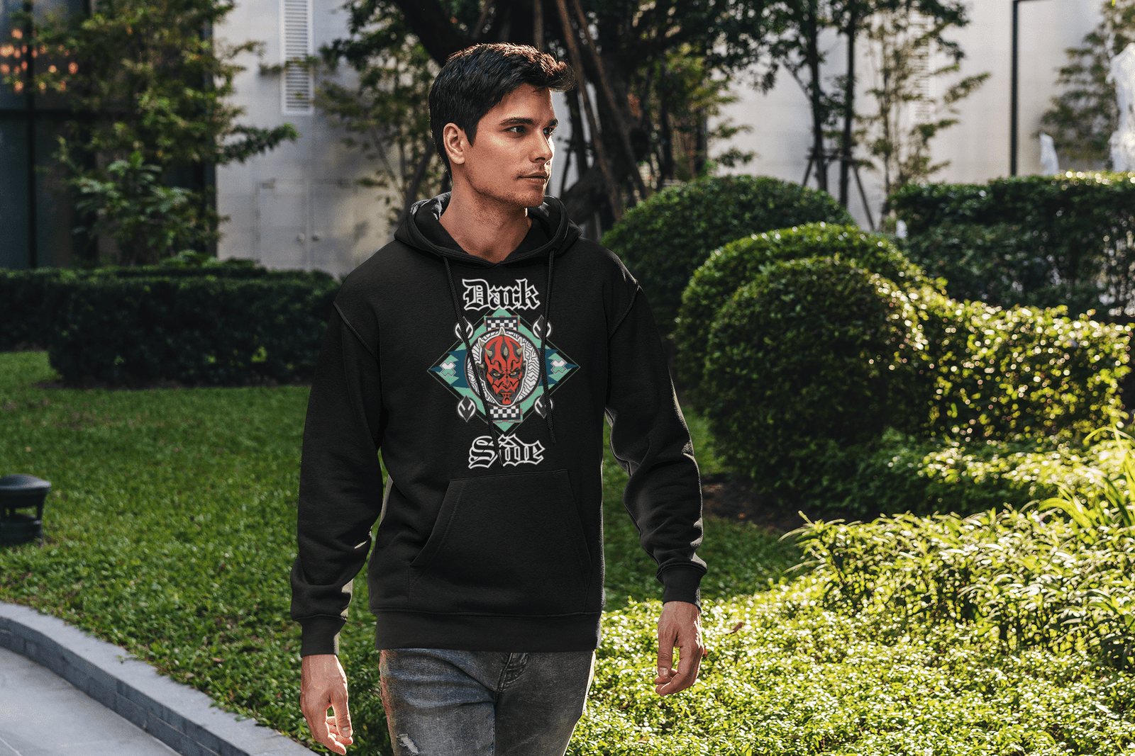 Model wearing a black 'Official Darth Maul Hoodie' by PodLyft, featuring a red-and-black Darth Maul graphic with yellow eyes, framed in a teal and mint green diamond pattern, with 'Dark' and 'Side' in gothic white text, paired with grey jeans against a plain beige background.