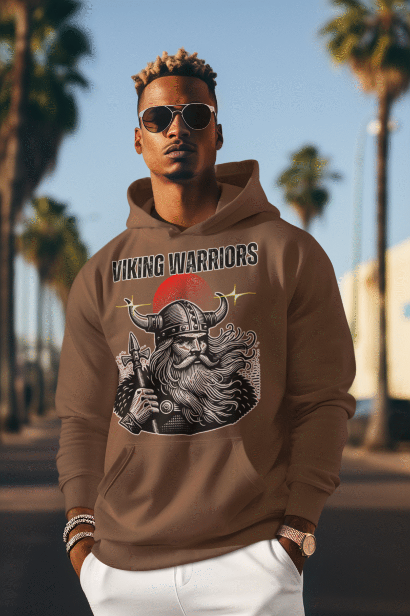 Man wearing a brown hoodie with a bold Viking warrior Hoodie. Standing confidently outdoors with palm trees in the background, embodying a fierce and rugged Norse aesthetic.