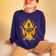 Woman wearing the PodLyft Women's Catastrophe Mystic Sweatshirt in deep purple, featuring a bold mystical enchantress design in gold and red with glowing purple flames, sitting against a soft beige background while smiling confidently.