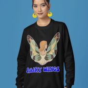 Woman wearing the Fairy Wings Hoodie from PodLyft, featuring a whimsical illustration of a fairy with colorful stained-glass-style wings and the bold blue text "Fairy Wings" on a black hoodie.