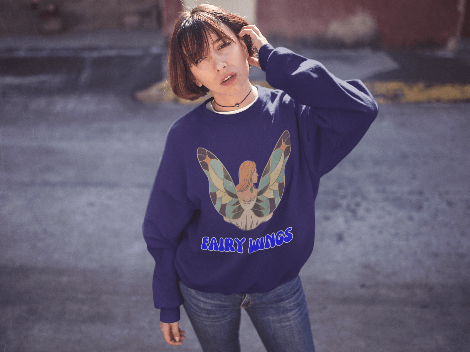 Stylish young woman wearing a navy blue Fairy Wings Hoodie with an artistic fairy graphic, posing outdoors.