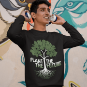 A smiling man wearing a black PodLyft Men's Plant the Future Sweatshirt, featuring a prominent tree design with roots and the text "PLANT THE FUTURE," adjusting headphones in front of a colorful mural.