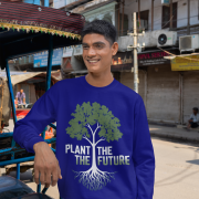 A smiling man wearing a navy blue PodLyft Men's Plant the Future Sweatshirt, featuring a prominent tree design with roots and the text "PLANT THE FUTURE," posing next to a rickshaw on a street.