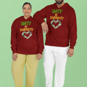 A man and a woman, possibly a couple of South Asian descent, standing in front of a light green background. Both are wearing maroon Unity in Diversity hoodies with a graphic of hands of various skin tones forming a heart shape. The man, with curly dark hair, has his arm resting on the woman's shoulder.