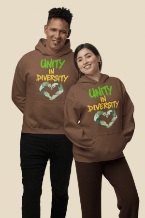 Two diverse models wear matching brown UNITY in DIVERSITY hoodies from PodLyft featuring a bold "UNITY in DIVERSITY" slogan in green and yellow graffiti-style text. Below the text is a powerful heart-shaped design made of interlocking hands in varying skin tones, symbolizing inclusion, equality, and social unity. This cause-based hoodie represents pride in diversity and is part of PodLyft’s mission-driven streetwear collection.