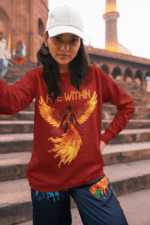 A young woman, possibly of Caucasian descent with light brown hair, wearing a maroon PodLyft women's Fire Within sweatshirt. The sweatshirt features a graphic of a human heart with stylized flames emanating from its top, and the text "FIRE WITHIN" written above and below it. She is looking directly at the camera with a subtle smile, standing against a plain light grey background.