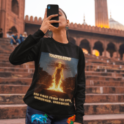 A young woman, possibly of South Asian descent, with long dark hair, wearing a black PodLyft Yagyaseni Fireborn sweatshirt. The sweatshirt features a stylized graphic of a woman's silhouette against a fiery, abstract background, with the text "YAGYASENI" written below. She is looking directly at the camera with a confident expression, her arms crossed, standing against a plain light grey background.