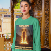 A young woman, possibly of South Asian descent, with long dark hair, wearing a mint green PodLyft Yagyaseni Fireborn sweatshirt. The sweatshirt features a stylized graphic of a woman's silhouette against a fiery, abstract background, with the text "YAGYASENI" written below. She is looking directly at the camera with a confident expression, her arms crossed, standing against a plain light grey background.