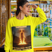 A young woman, possibly of South Asian descent, with long dark hair, wearing a yellow PodLyft Yagyaseni Fireborn sweatshirt. The sweatshirt features a stylized graphic of a woman's silhouette against a fiery, abstract background, with the text "YAGYASENI" written below. She is looking directly at the camera with a confident expression, her arms crossed, standing against a plain light grey background.