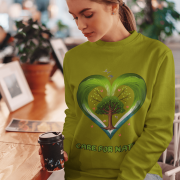 A young woman, possibly of Caucasian descent, with light brown hair, wearing an olive green PodLyft Women's Eco Love Sweatshirt. The sweatshirt features a circular graphic with the phrase "CARE FOR NATURE" prominently displayed. She is looking directly at the camera with a confident yet gentle expression, standing against a plain light grey background.