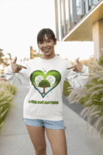 A young woman, possibly of Caucasian descent, with light brown hair, wearing a white PodLyft Women's Eco Love Sweatshirt. The sweatshirt features a circular graphic with the phrase "CARE FOR NATURE" prominently displayed. She is looking directly at the camera with a confident yet gentle expression, standing against a plain light grey background.