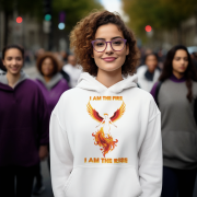 A young woman, possibly of Caucasian descent, with light brown hair pulled back, wearing a white PodLyft Women's Revolution Hoodie. The hoodie features a graphic of a stylized, strong female figure, with the text "I AM THE FIRE I AM THE REVOLUTION" below it. She is looking directly at the camera with a confident expression, standing against a plain light grey background.