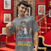 A young man, possibly of Caucasian descent, with short dark hair and a beard, wearing a grey PodLyft Pataka t-shirt. The t-shirt features a flirty graphic with the text, "Girl, were you born on Diwali? Because You are PATAKA." He is looking directly at the camera with a confident expression, standing against a plain light grey background.