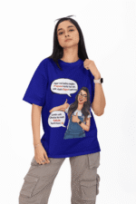 A woman wearing a navy blue PodLyft Girls Savage Queen Tee with a funny graphic and Hindi text. She is standing outdoors with a blurred street and city lights in the background. The graphic features a woman giving a thumbs-up, with text bubbles that translate to "If a guy proposes to me, I reject him" and "But I salute his choice.