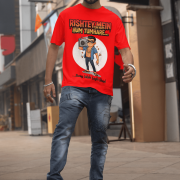 A young man, possibly of Caucasian descent, with short dark hair and a beard, wearing a red PodLyft Men's Bollywood Swag T-shirt. The t-shirt features a graphic with a funny movie dialogue. He is looking directly at the camera with a confident expression, standing against a plain light grey background.