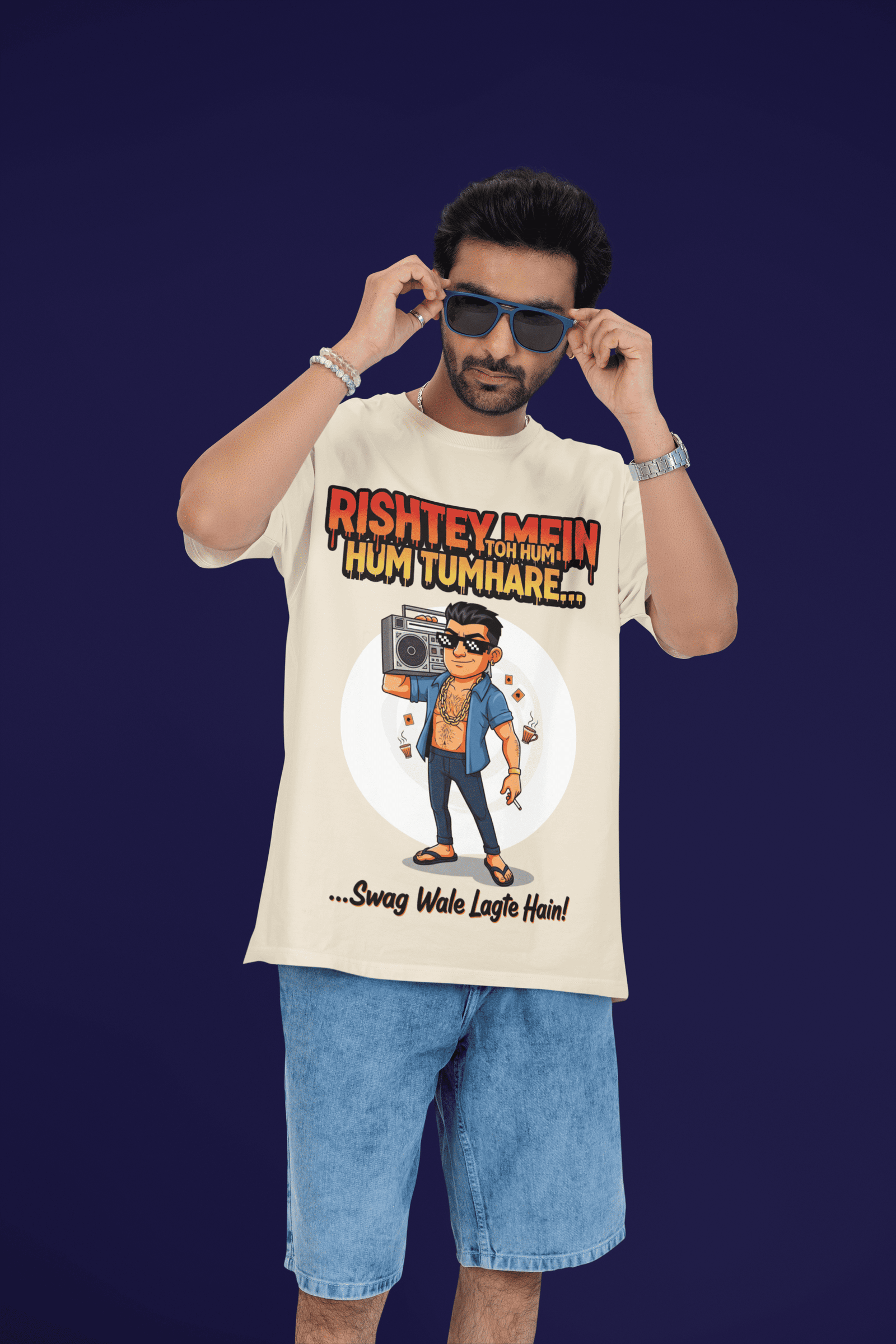 A young man, possibly of Caucasian descent, with short dark hair and a beard, wearing a black PodLyft Men's Bollywood Swag T-shirt. The t-shirt features a graphic with a funny movie dialogue. He is looking directly at the camera with a confident expression, standing against a plain light grey background.