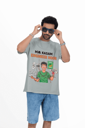 Man wearing PodLyft Engineering Stress Tee in light gray featuring 'Ma Kasam Engineer Hoon' design with cartoon engineer juggling coding tasks, paired with denim shorts and sunglasses