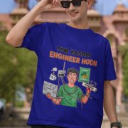 A man wearing a navy blue PodLyft Men's Engineering Stress Tee while holding his sunglasses up on a sunny day. He is standing outdoors with a large, classical building in the background. The graphic on the shirt shows a stressed-out male engineer surrounded by broken electronics, wires, and coffee, with the Hindi text "MAA KASAM ENGINEER HOON" and a book titled "LEARN PYTHON 7 DAYS!