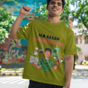A man smiling and posing in an olive green PodLyft Men's Engineering Stress Tee outdoors with a wall mural in the background. The graphic on the shirt shows a stressed-out male engineer surrounded by broken electronics, wires, and coffee, with the Hindi text "MAA KASAM ENGINEER HOON" and a book titled "LEARN PYTHON 7 DAYS!