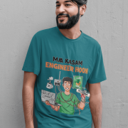 A man wearing a petrol blue PodLyft Men's Engineering Stress Tee and smiling while leaning against a grey wall. The graphic on the shirt shows a stressed-out male engineer surrounded by broken electronics, wires, and coffee, with the Hindi text "MAA KASAM ENGINEER HOON" and a book titled "LEARN PYTHON 7 DAYS!