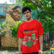 A man smiling and posing in a red PodLyft Men's Engineering Stress Tee outdoors with a wall mural in the background. The graphic on the shirt shows a stressed-out male engineer surrounded by broken electronics, wires, and coffee, with the Hindi text "MAA KASAM ENGINEER HOON" and a book titled "LEARN PYTHON 7 DAYS!