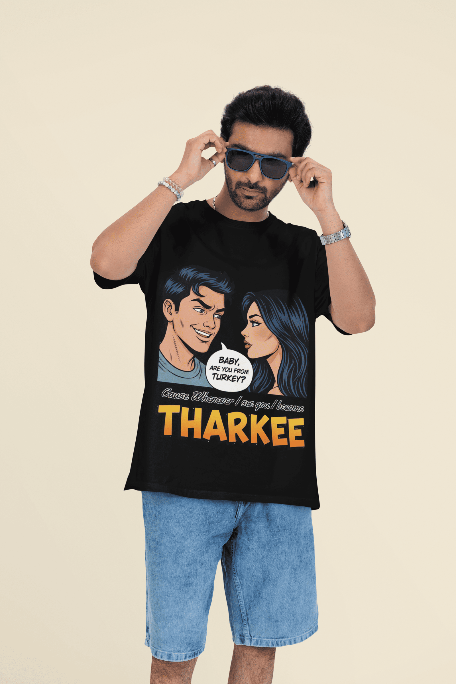 A young man, possibly of Caucasian descent, with short dark hair and a beard, wearing a black PodLyft t-shirt. The t-shirt features a humorous graphic with the Hindi word "THARKEE." He is looking directly at the camera with a confident expression, standing against a plain light grey background.