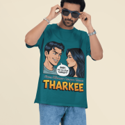 A young man, possibly of Caucasian descent, with short dark hair and a beard, wearing a petrol blue PodLyft t-shirt. The t-shirt features a humorous graphic with the Hindi word "THARKEE." He is looking directly at the camera with a confident expression, standing against a plain light grey background.