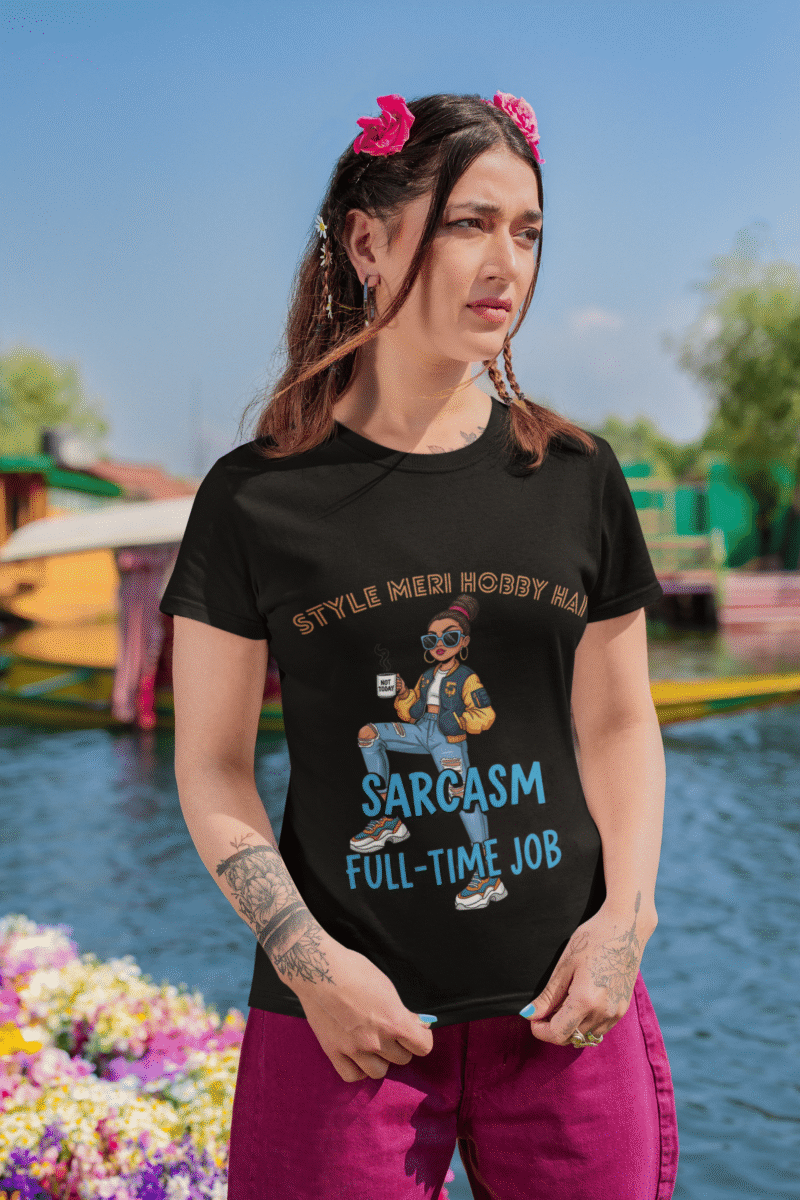 Woman wearing PodLyft Women's Full-Time Sarcasm Tee in black with pink flowers in hair against colorful waterside background