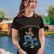 Woman wearing PodLyft Women's Full-Time Sarcasm Tee in black with pink flowers in hair against colorful waterside background