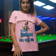 A woman wearing a light pink PodLyft Women's Full-Time Sarcasm Tee in a mountain setting, holding a hiking pole. The graphic features a stylized woman character holding a coffee cup, with the text "STYLE MERI HOBBY HAI" and "SARCASM FULL-TIME JOB.