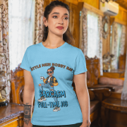A woman wearing a sky blue PodLyft Women's Full-Time Sarcasm Tee in a cozy, wood-paneled room. The graphic features a stylized woman holding a coffee cup, with the text "STYLE MERI HOBBY HAI" and "SARCASM FULL-TIME JOB."