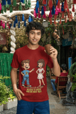 PodLyft Cheesy Pickup Line T-shirt in maroon, worn by a smiling man holding a cup outdoors under colorful decorations. The shirt shows the funny pizza pickup line design.