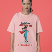 Baby Pink Desi Swag Oversized Tee for women by PodLyft. A pastel pink graphic t-shirt showing a woman in a salwar kameez with the text "Hum Kehte hain STANDARD HAI."