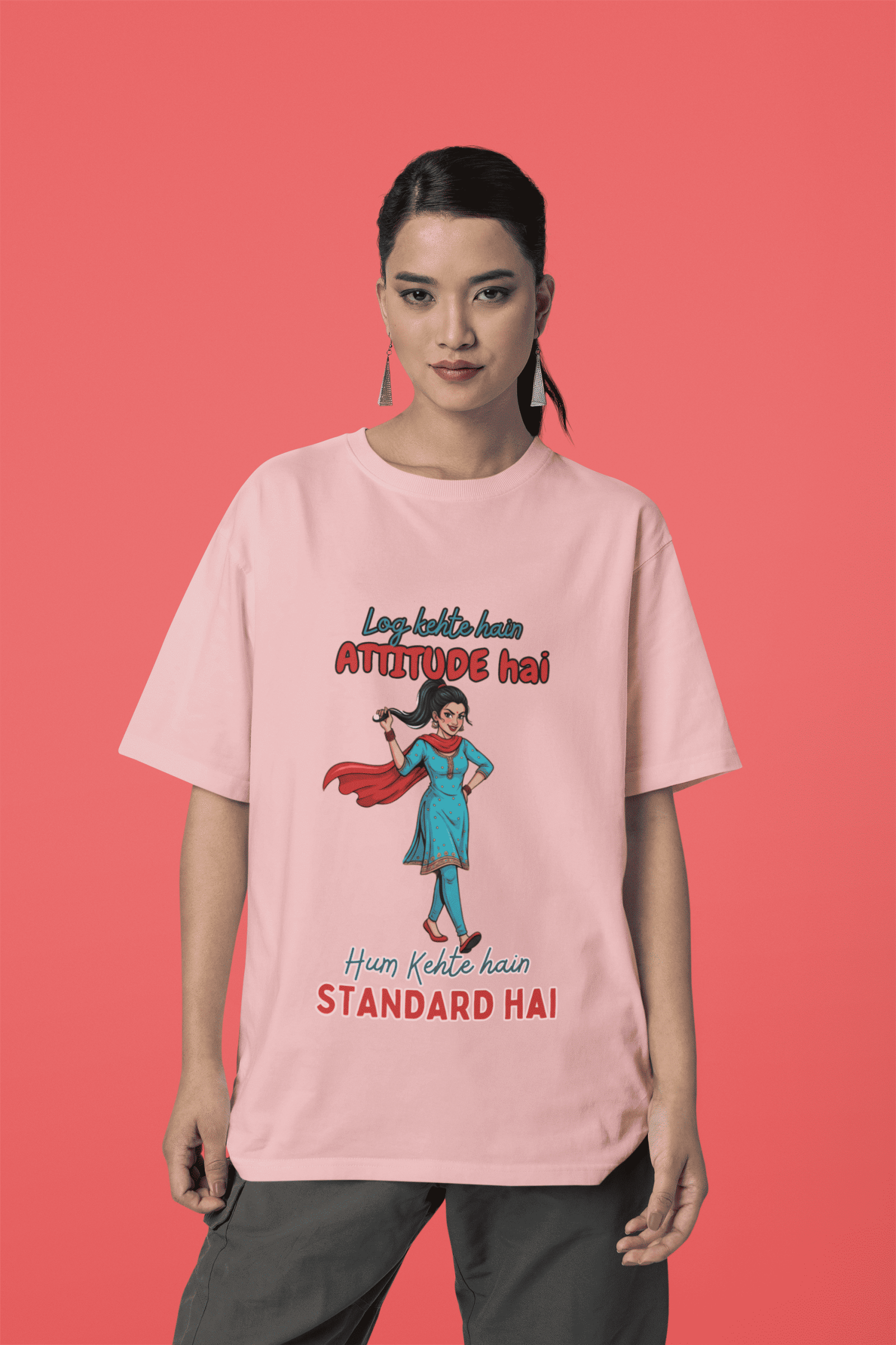 Baby Pink Desi Swag Oversized Tee for women by PodLyft. A pastel pink graphic t-shirt showing a woman in a salwar kameez with the text "Hum Kehte hain STANDARD HAI."