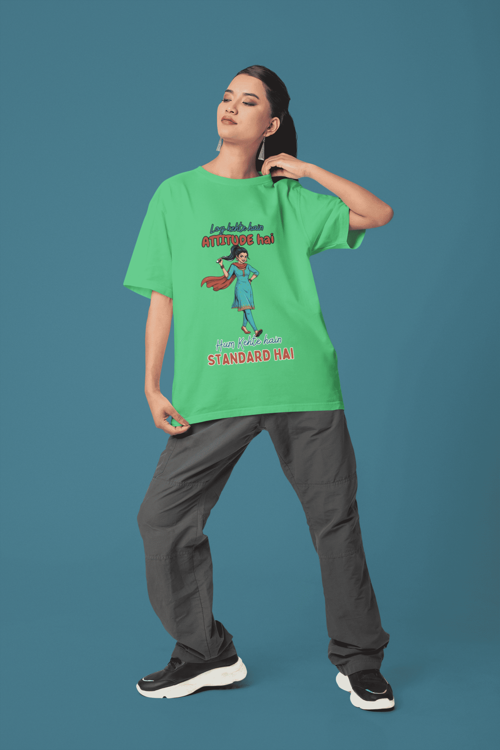 Bright Green Desi Swag Oversized Tee by PodLyft. A model poses against a blue background wearing a green streetwear t-shirt with a witty Desi slogan.