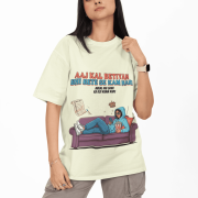 PodLyft Modern Beti Oversized T-shirt – Zero Kaam Attitude Edition in beige. A model wears a cream-colored oversized tee featuring a humorous graphic of a girl relaxing on a sofa with the Hindi text "Aaj Kal Betiyan Bhi Bete Se Kam Nahi."